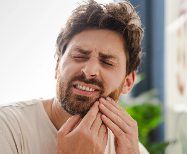 Patient experiencing tooth pain caused by dental decay