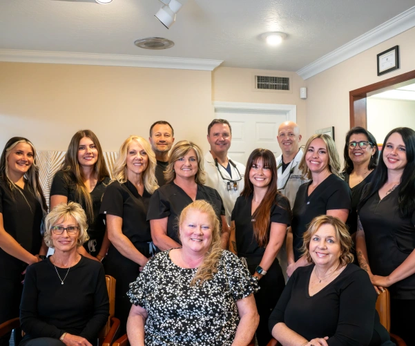 Dental practice team posing together for a group photo in the office